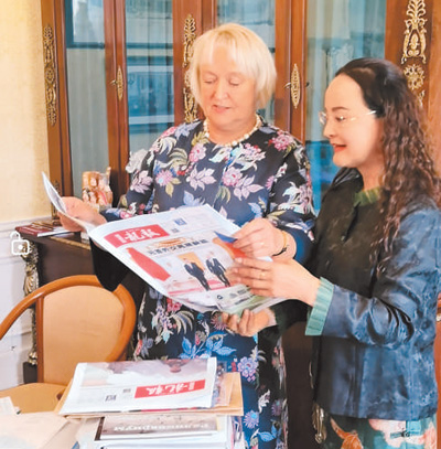 李雙杰（右）向俄羅斯友人展示《龍報》。